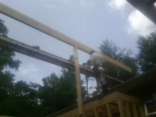 Carpenter setting a ridge beam over a new addition frame — Ice Dam Removal by Roofing Brothers in Dwight