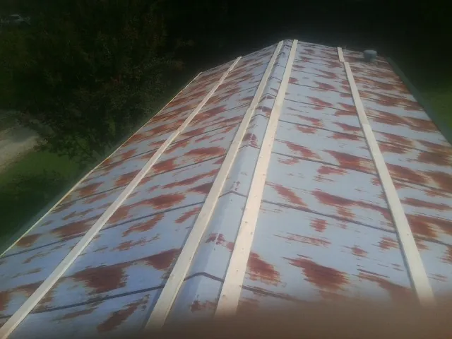 Rusted metal roof panels with new wood purlins before replacement — Storm Damage Roof Repair in Dwight by Roofing Brothers