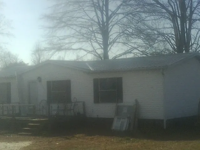 New metal roof on a white painted brick home on a foggy morning in Dwight